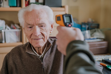Old man measured temperature with thermometer