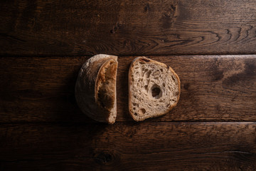 Zdjęcie bochenka chleba i noża na drewnianym, naturalnym stole - obrazy, fototapety, plakaty
