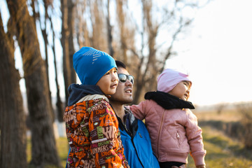 father with children in nature play and enjoy the sunset