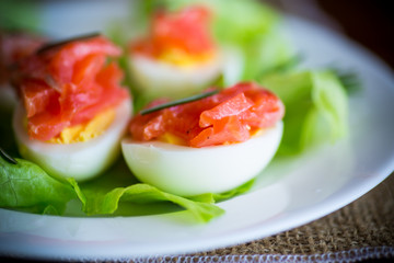 boiled eggs with salted red fish and salad leaves