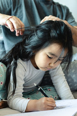 Fototapeta premium father takes care of his daughter while she draws