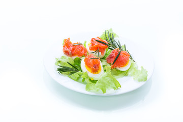 boiled eggs with salted red fish and salad leaves
