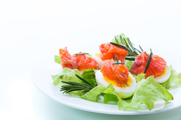 boiled eggs with salted red fish and salad leaves