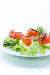 boiled eggs with salted red fish and salad leaves