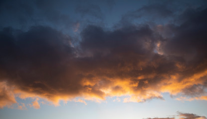 Obraz premium Clouds in the sky lit by the setting evening sun