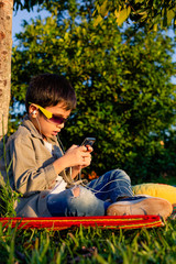 boy listens to music in the patio of his house in the sun