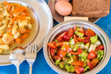 Simple Rustic Food Breakfast Set. Vegetable Salad, Stewed Potatoes with Carrots, Boiled Eggs, Bread and Butter. Stock Photo.