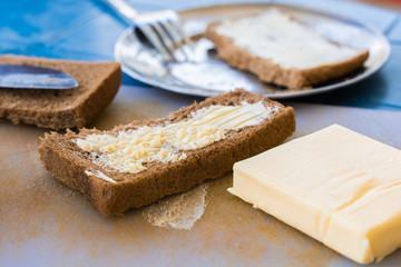 Bread with butter, set for a short breakfast. Simple rustic vegetarian food concept. Stock photo.