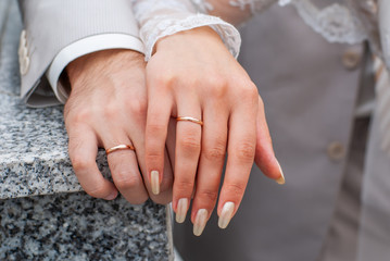 Hands of just married couple. Newlyweds woman and man with wedding bands rings. Stock photo.