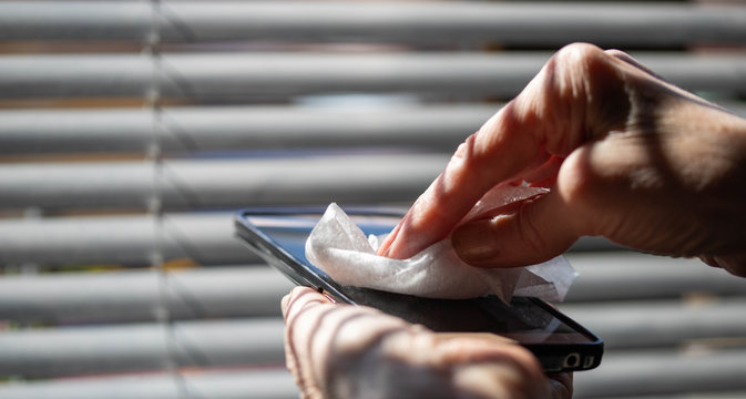 woman hands cleaning smartphone sanitizing coronavirus prevention