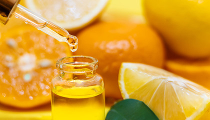 orange essential oil on a yellow background. Selective focus.