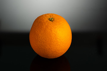 whole orange closeup on a glare dark background