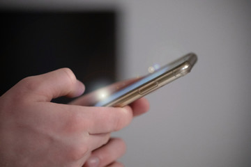 The man holding  his modern smartphone, close up, phone with flare light.
