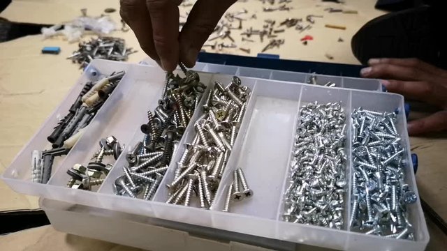 Hands separate screws by type