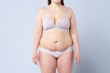 Tummy tuck, flabby skin on a fat belly, plastic surgery concept