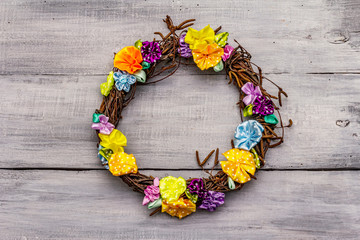 Spring composition of a wreath of birch branches and craft colorful flowers