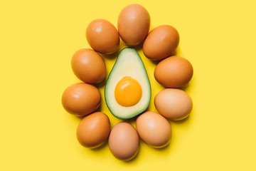 yolk in avocado and eggs on a yellow background. easter concept