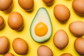 yolk in avocado and eggs on a yellow background. easter concept