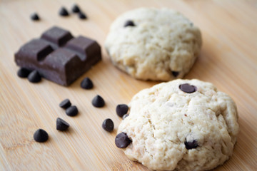 Homemade chocolate chip cookies and dark chocolate in the background
