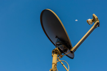 Satellite Dish with Moon in the Background and Clear Sky 