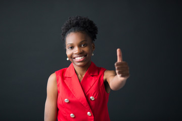 beautiful young african woman on black background with hand gesture