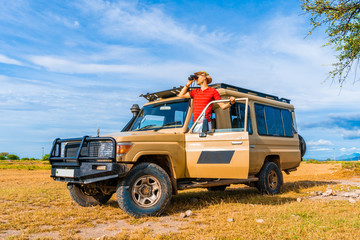 Safari animal explorer looking for a wildlife from the heep front row. Real explorer of Ngorongoro national park. © Aerial Film Studio