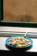 Plate of pasta with tuna on a rustic, Mediterranean style window. Selective focus.