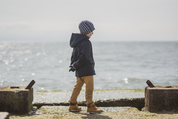 A boy is walking at the pier feeling happy and freedom after a long quarantine isolation at home