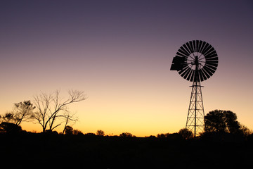 Sunset in Australian desert with windmill silhouette 