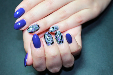 Fashionable manicure gel Polish on natural nails with abstract bright and geometric design on the hands of a modern girl