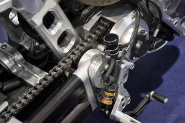 Motorcycle chain. It is a metallic chain that is used to transmit power from the engine to the rear wheel.