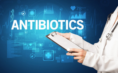 young doctor writing down notes with ANTIBIOTICS inscription, healthcare concept