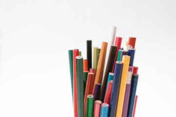 Fototapeta premium Colored pencils in a white background to make drawings and crafts at home during quarantine