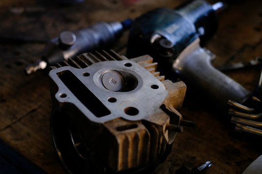 Motorcycle mechanic repairing engine cylinder head, motorcycle head