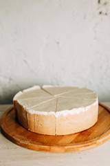  Cake cut into slices on a short dough. Cream cheesecake on a wooden Board.