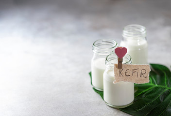 Fermented drink kefir in a glass jar on a light background. Probiotic cold fermented dairy drink.