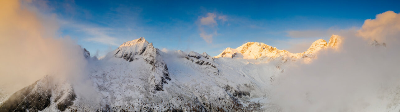 Aerial panoramic of Monte Disgrazia and Corni Bruciati covered by mist at sunset, Val Masino, Valtellina, Sondrio, Lombardy, Italy