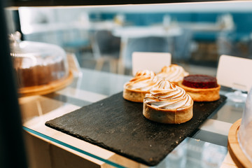 Shortcrust pastry in desserts and the hands of the waiter. Lemon cake with airy whipped cream.