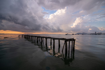 Obraz premium Wooden bridge at sea with Penang Bridge at background in majestic cloudy morning,