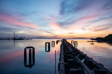 Fototapeta premium Sunrise broken bridge of fisherman jetty at Karpal Singh Drive, Penang, Malaysia.
