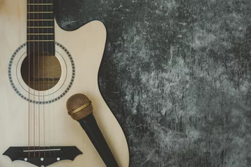 Gordijnen Table top view of music instrument tools concept background.Flat lay of sign to sing for musician or party equipment.Guitar with microphone on modern grey cement.copy space for creative design. © osabee