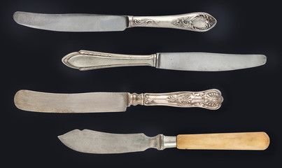 Vintage worn out spoon, fork and knifes isolated on a white background. Retro silverware.