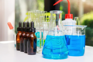 Blue experiment water in beaker and flask in chemistry science laboratory. Group of laboratory flasks with liquid inside. Researchers are developing vaccines and medicine to treat the COVID-19 virus.