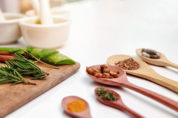 Top view of Herbal medicine preparation with fresh herbs and dried flowers, aromatherapy essential oil and mortar with pestle used in natural alternative remedies on white table.