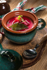 Red borscht soup in bowl.