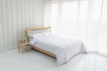 Fototapeta na wymiar Interior white bedroom with white curtains.