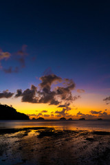 Fototapeta na wymiar Sunset on the tropical beach. Orange sunset on the ocean. Colorful sunset in the tropics