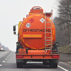 Fuel truck with new bright orange barrel with 33 1203 dangerous class sign and Russian inscription...