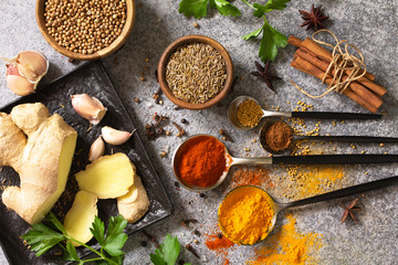 Set of Indian spices and herbs selection on a stone table. Top view flat lay background.