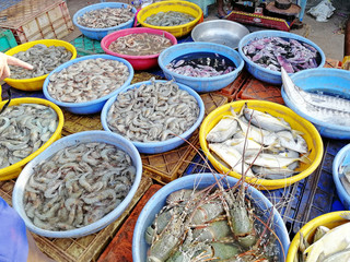 freshly caught seafood, fish and prawns lie in cups at a local market in India. Fresh and healthy products